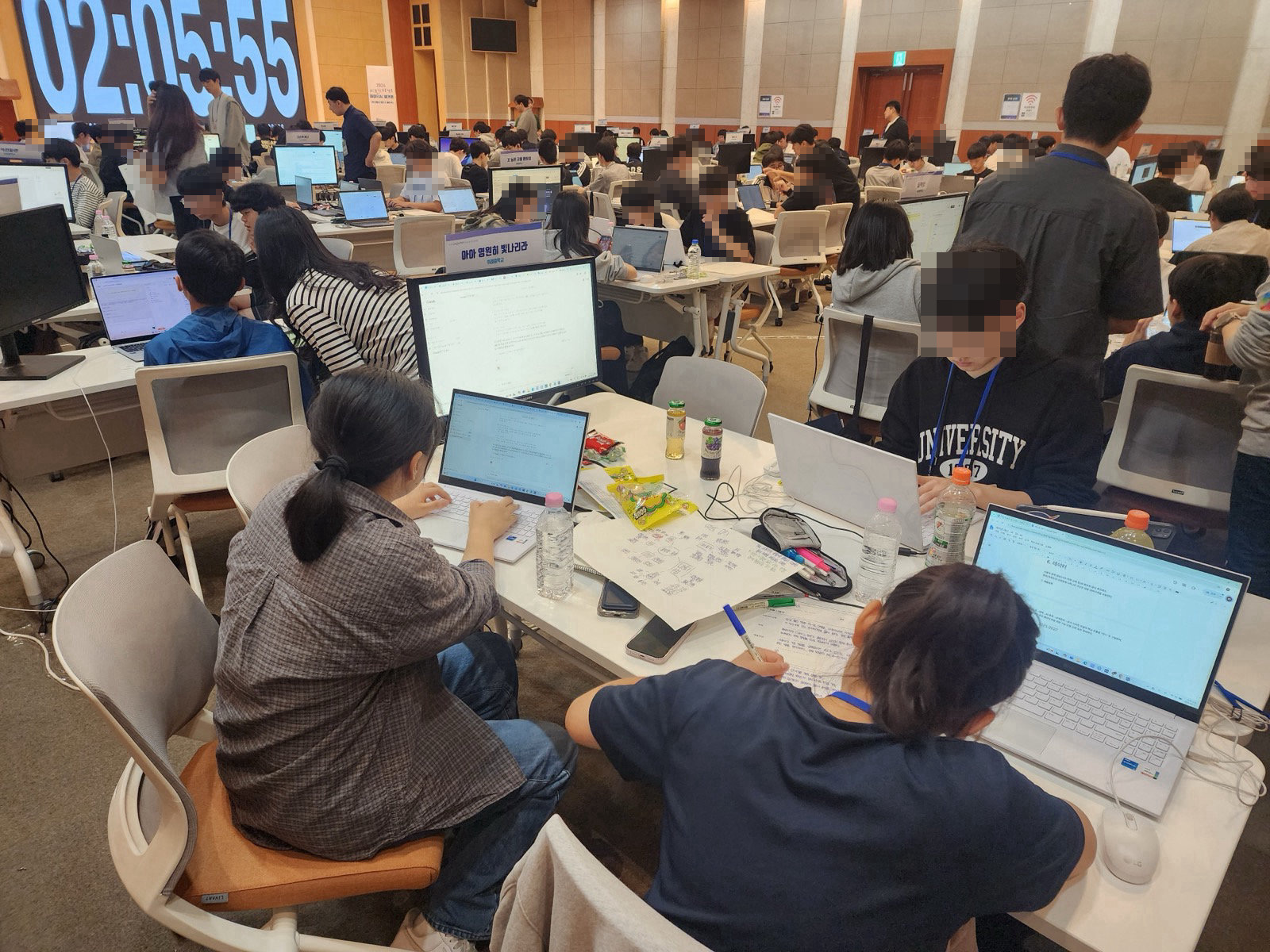 한 팀이 손으로 그린 기획 마인드맵을 옆에 두고 노트북으로 기획안을 작성하는 모습