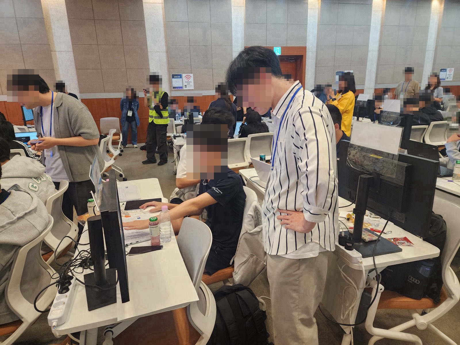현장 멘토가 학생 자리 옆에 서서 모니터 화면을 함께 들여다보는 모습