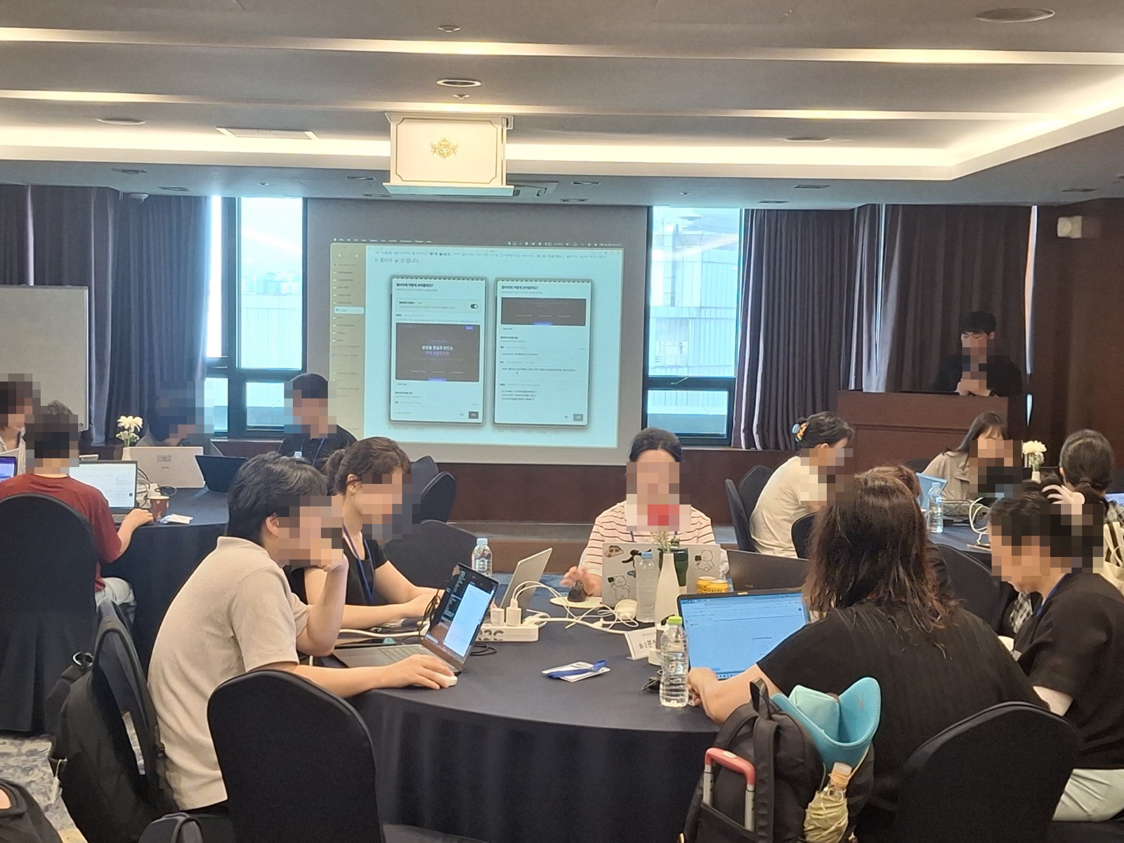 원탁에 둘러앉은 선생님들이 노트북으로 각자의 수업 도구를 만드는 모습